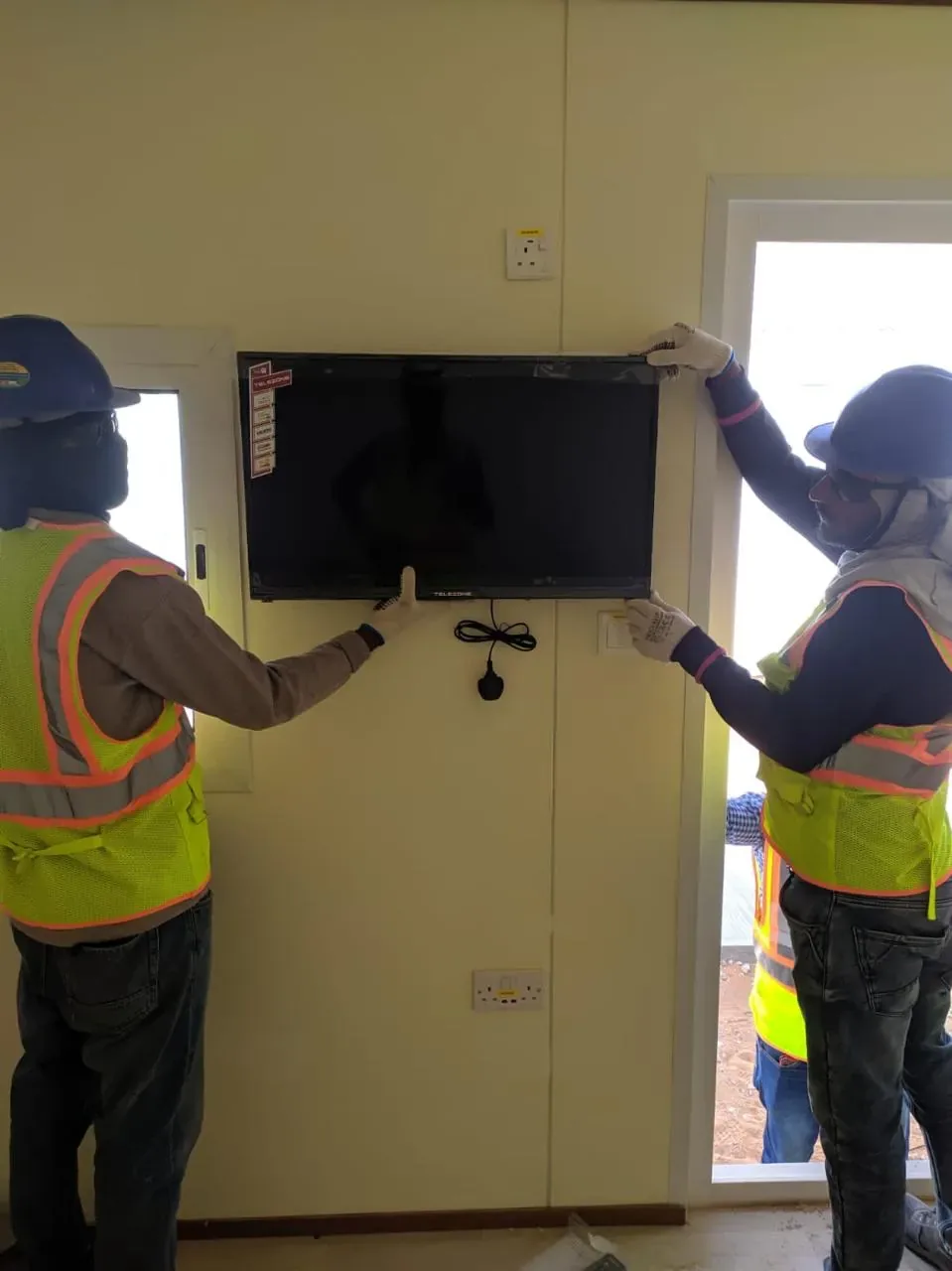 Yanbu hotel, port and staff-housing reference showing smart TV installation inside labour camp accommodation rooms for the Aramco JGC project
